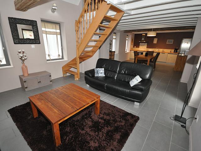 Salon du gîte avec canapés en cuir et table basse en bois